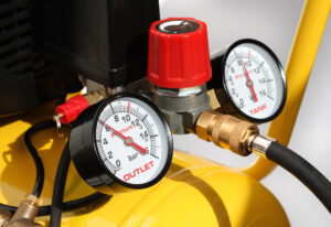 Pressure gauges attached to a yellow air compressor in El Paso.