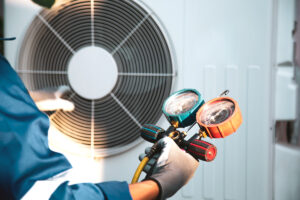A technician performing maintenance on a white commercial air system in El Paso.