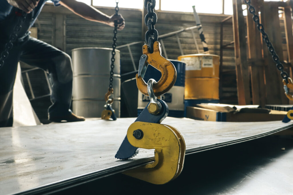 A yellow hoist system in El Paso lifts a piece of metal.