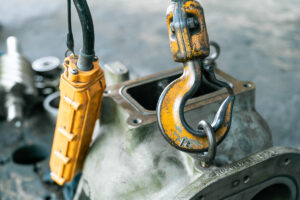 A yellow hoist system hook picking up a piece of machinery in El Paso.